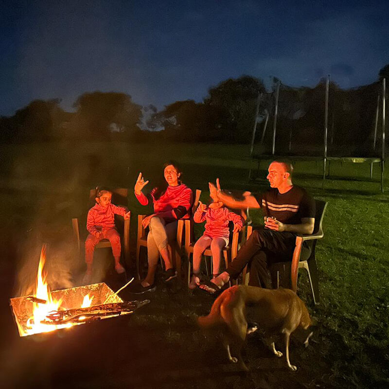 Waterwoods family and friends gathered around a bonfire with their dogs under the night sky
