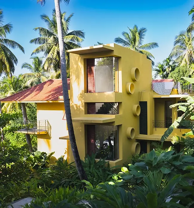 Modern tropical architecture of Waterwoods Havelock surrounded by dense coconut trees and green landscape.
