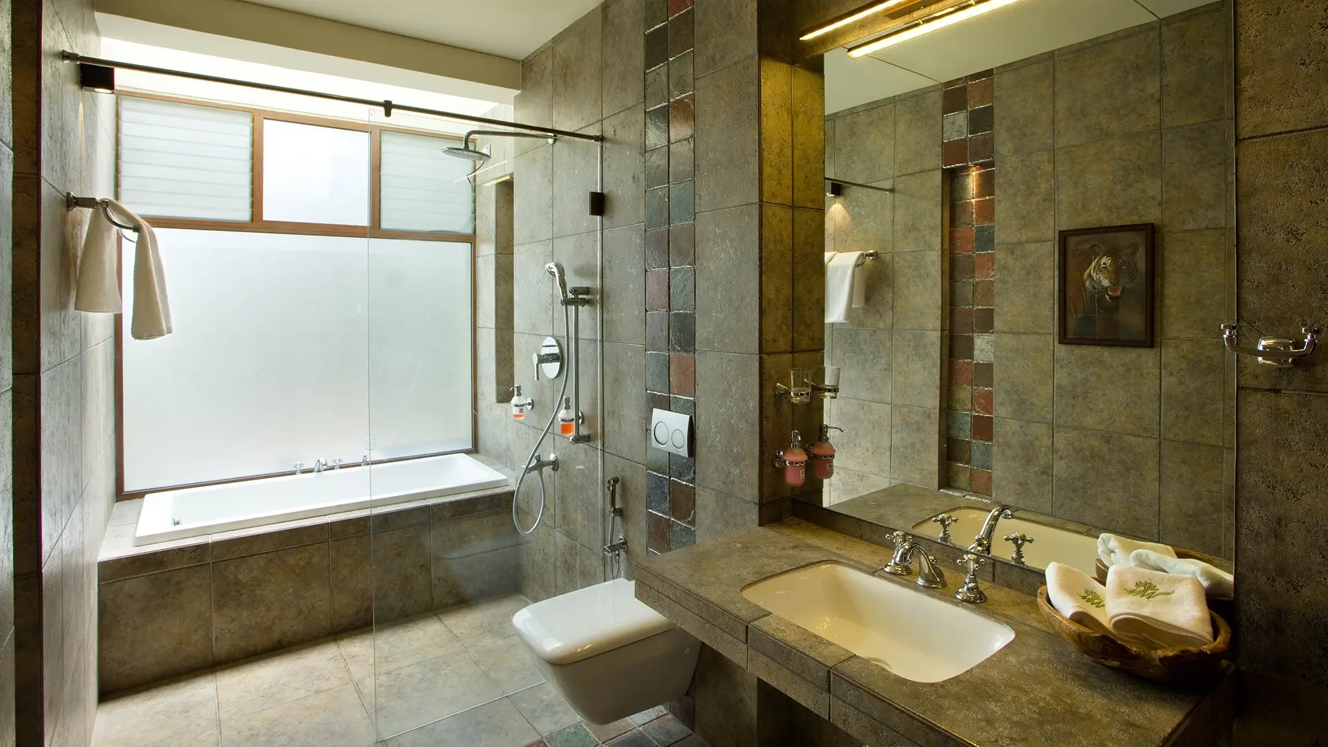 Modern bathroom with rain shower and natural stone design at Waterwoods Kabini Lodge