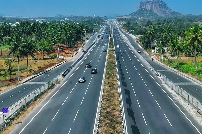 Scenic highway drive to Waterwoods Kabini surrounded by palm trees and hills