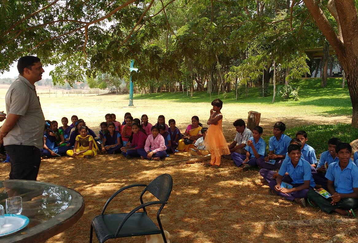 Local students attending an outdoor conservation awareness session under Waterwoods Kabini’s education support program.