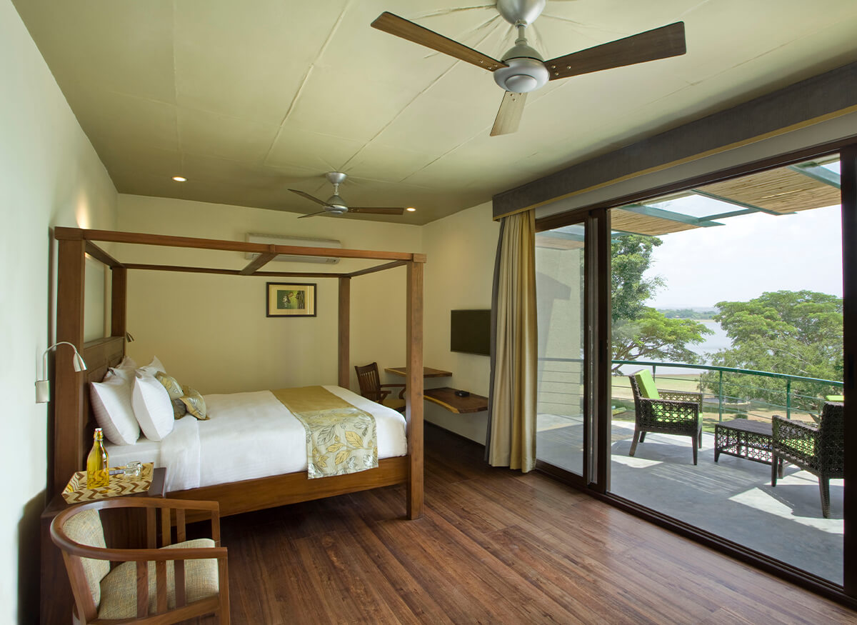 Junior Family Room Cassia at Waterwoods Kabini with wooden flooring and private balcony overlooking backwaters.
