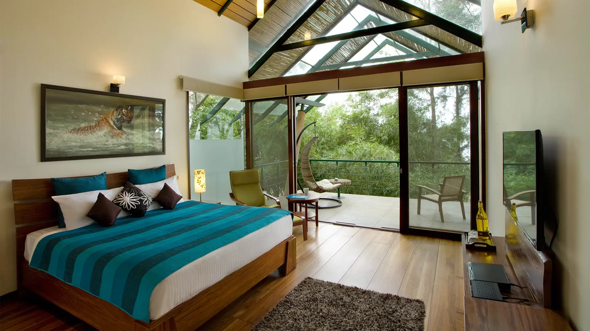 Spacious Waterwoods Kabini bedroom with glass walls and panoramic forest view