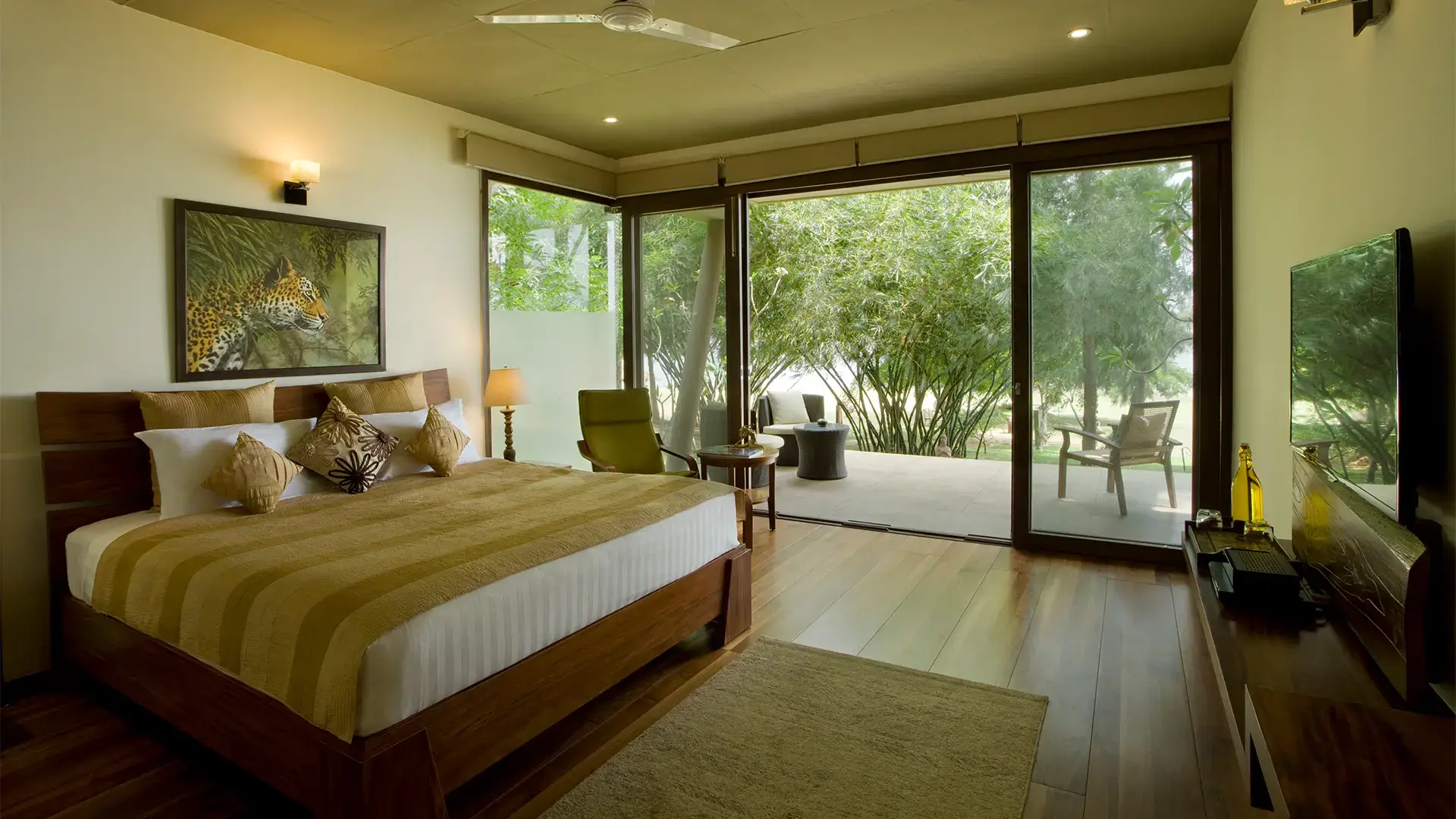 Luxury king room with large windows overlooking the Kabini River at Waterwoods Lodge
