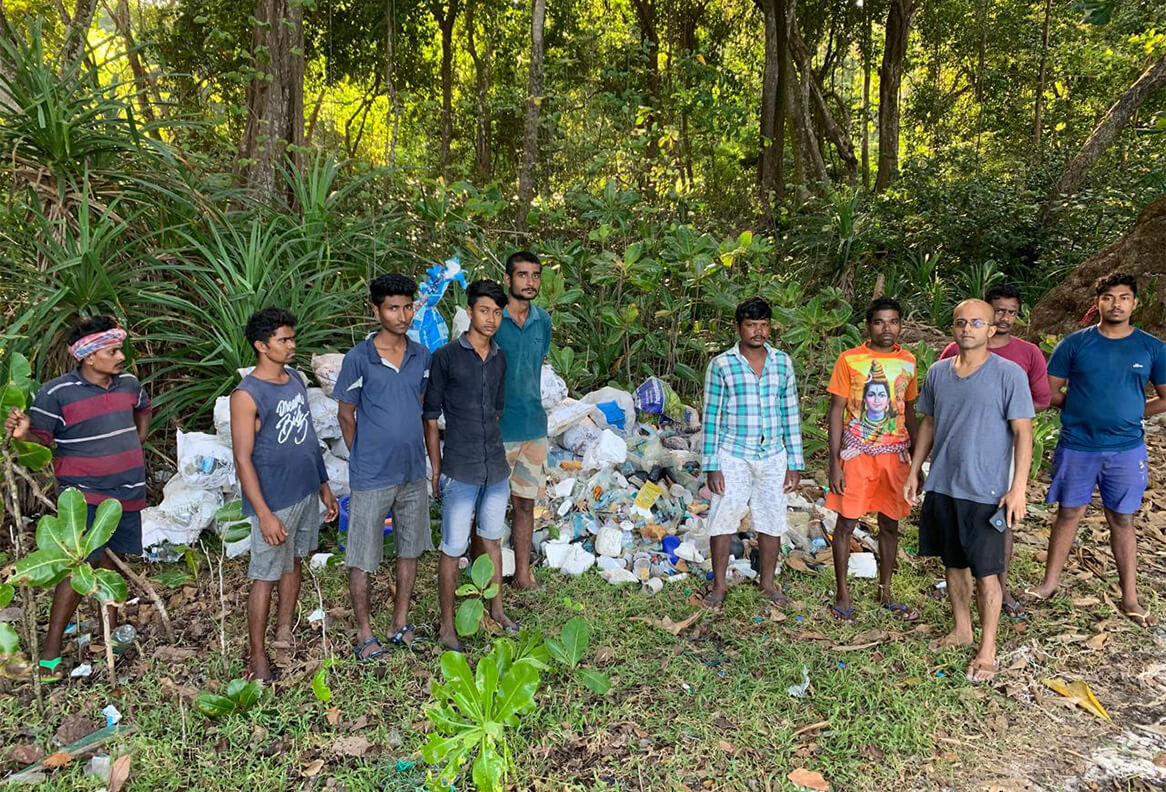 Waterwoods Kabini staff and conservation volunteers posing with collected waste after an eco-cleanup activity near the forest.