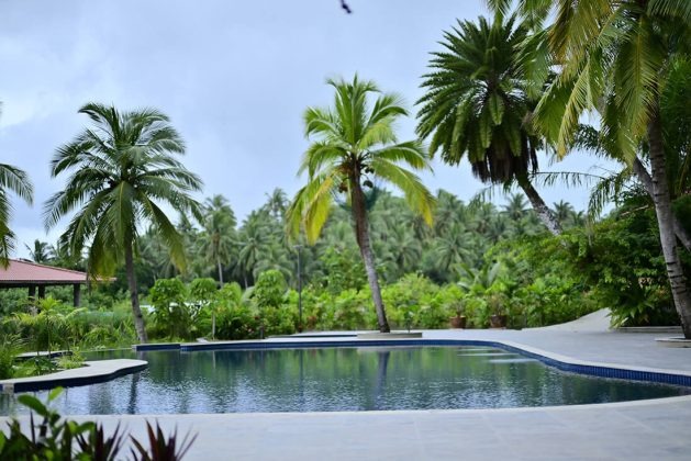 Scenic view of Waterwoods Havelock pool surrounded by coconut trees and tropical plants.